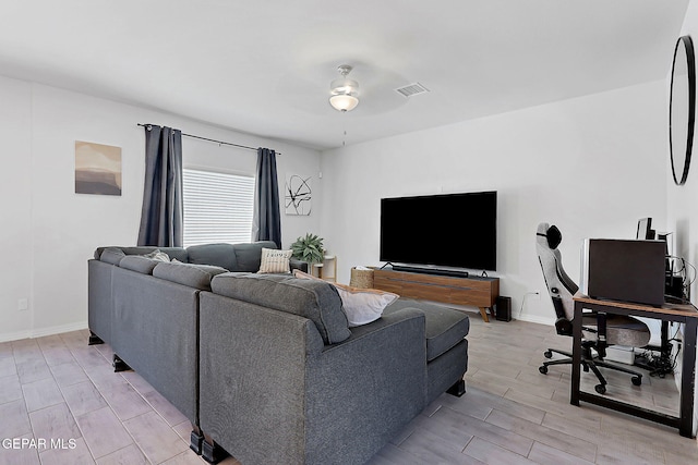 living room featuring ceiling fan, visible vents, wood finish floors, and baseboards