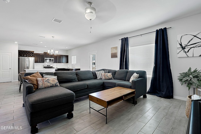 living area with visible vents, baseboards, wood finish floors, recessed lighting, and ceiling fan with notable chandelier