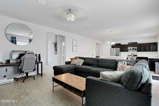 living room with visible vents, recessed lighting, light wood-style flooring, and ceiling fan