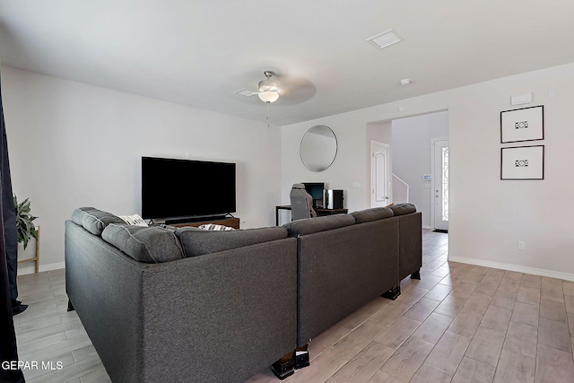 living room with visible vents, light wood-style flooring, ceiling fan, and baseboards
