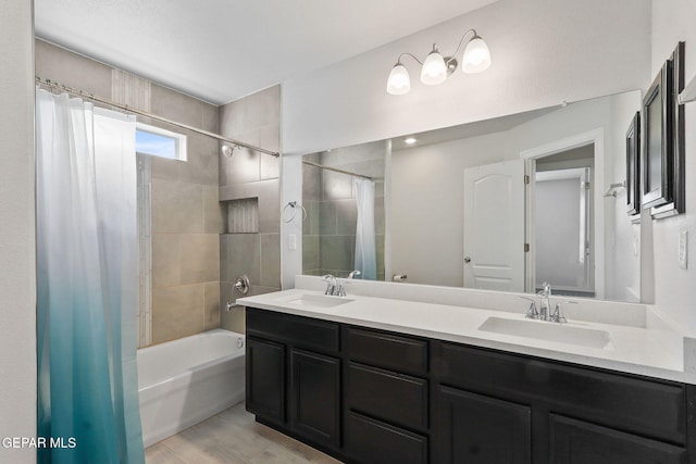 full bath featuring double vanity, a sink, and shower / bath combo