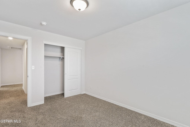 unfurnished bedroom featuring carpet floors, baseboards, and a closet