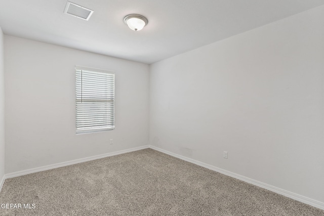 spare room with visible vents, carpet, and baseboards