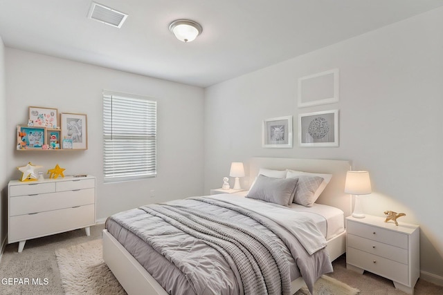 bedroom with baseboards, visible vents, and light carpet