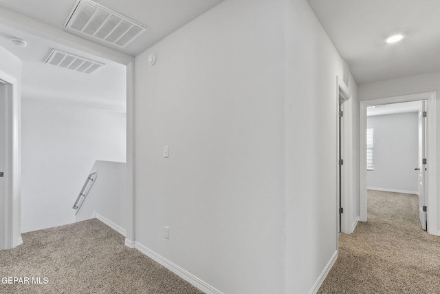 hall featuring visible vents, carpet flooring, and baseboards