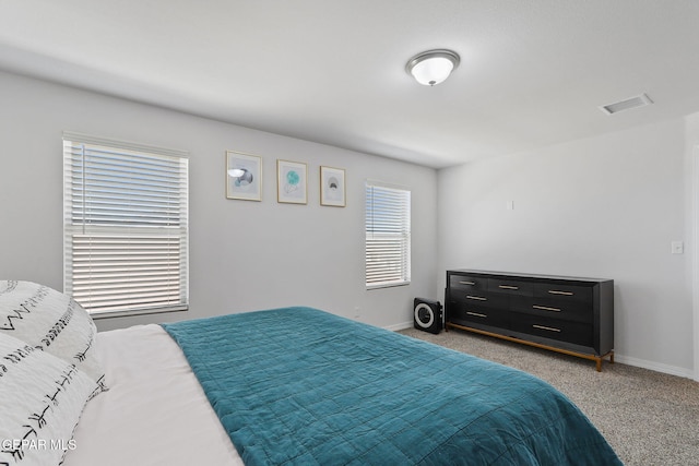 bedroom featuring baseboards, carpet flooring, and visible vents