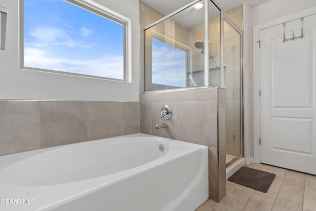 full bathroom featuring a garden tub and a stall shower