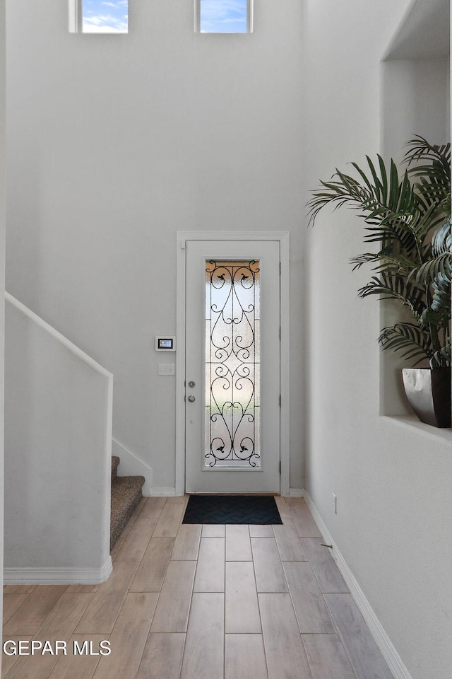 foyer entrance with stairway, plenty of natural light, and light wood-style floors