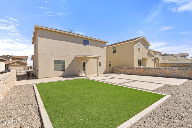 rear view of property featuring a lawn, a fenced backyard, a patio area, and stucco siding