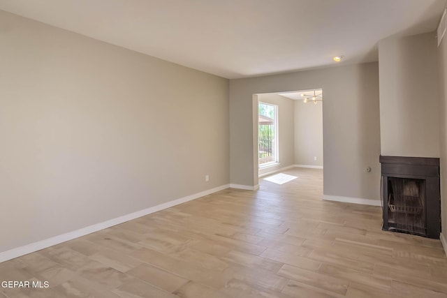 1721 Villa Santos Cir, El Paso, TX 79935 - unfurnished living room with an inviting chandelier, a fireplace, baseboards, recessed lighting, and light wood-style flooring