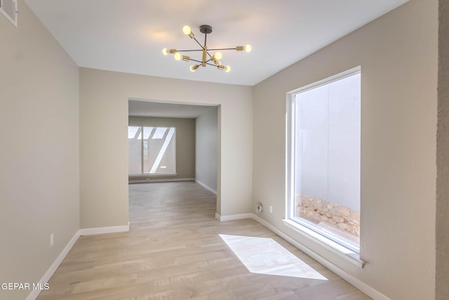1721 Villa Santos Cir, El Paso, TX 79935 - unfurnished room with visible vents, baseboards, an inviting chandelier, and light wood finished floors