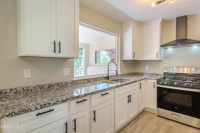 1721 Villa Santos Cir, El Paso, TX 79935 - kitchen featuring light stone countertops, wall chimney exhaust hood, gas stove, a sink, and white cabinetry