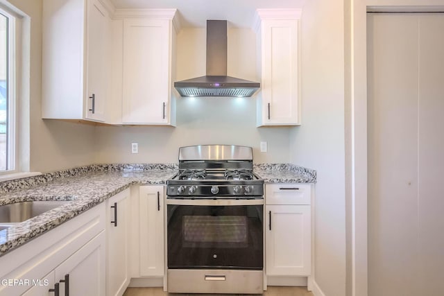 1721 Villa Santos Cir, El Paso, TX 79935 - kitchen featuring wall chimney range hood, white cabinets, and gas range