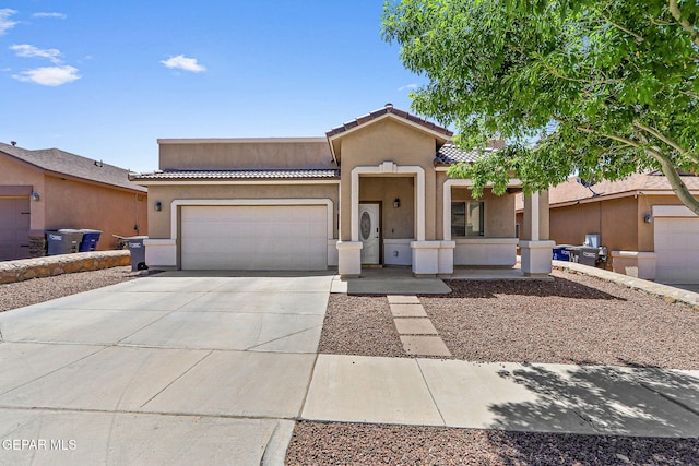 view of front of home with an attached garage, stucco siding, driveway, and a tile roof