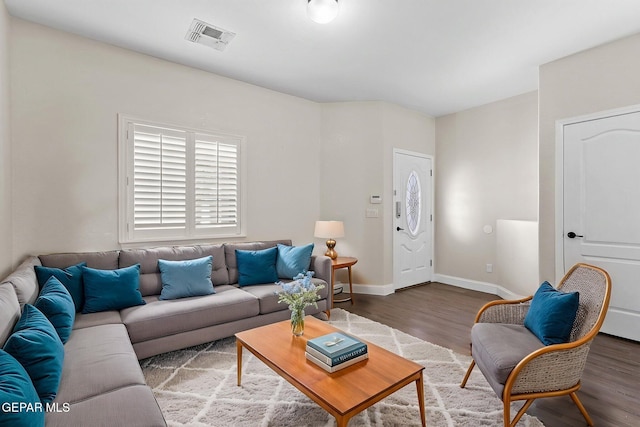 living area with baseboards, wood finished floors, and visible vents