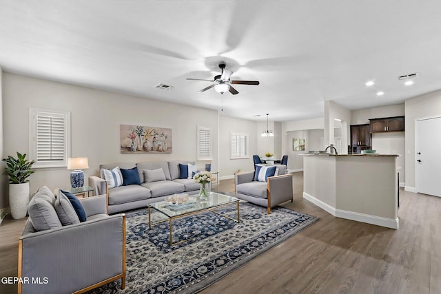 living area featuring ceiling fan, wood finished floors, and visible vents