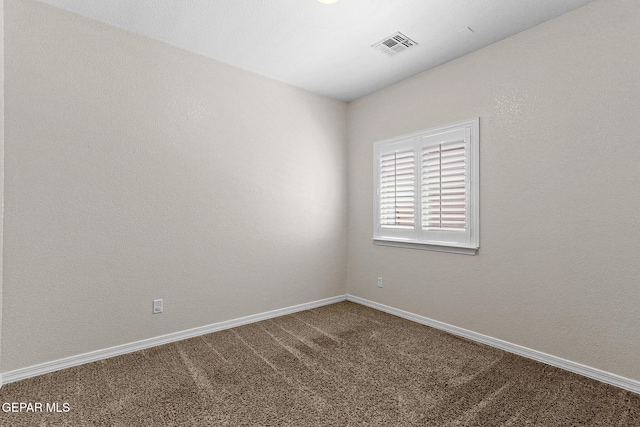 spare room featuring carpet flooring, baseboards, and visible vents