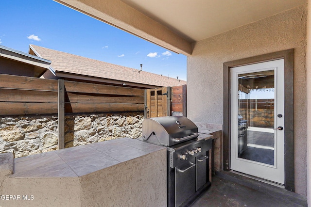 view of patio / terrace with fence, grilling area, and exterior kitchen
