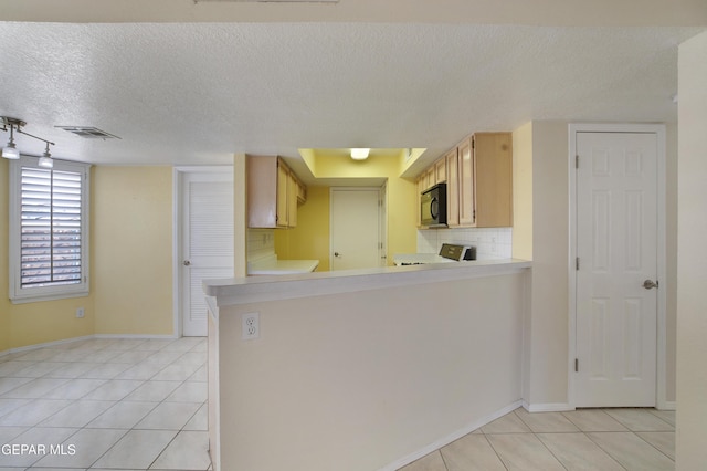 kitchen with visible vents, a textured ceiling, light tile patterned floors, and black microwave