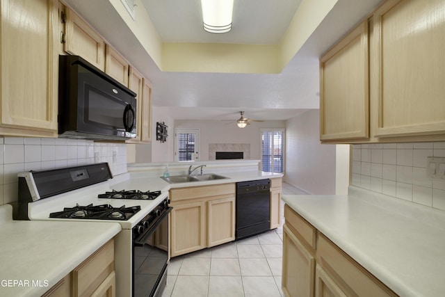 kitchen featuring light brown cabinetry, backsplash, a sink, and black appliances