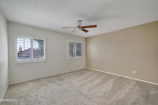 carpeted spare room with a ceiling fan, a textured ceiling, and baseboards