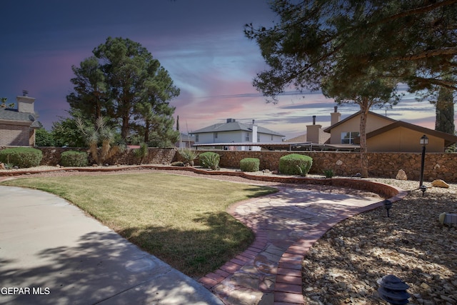 yard at dusk with a patio and fence