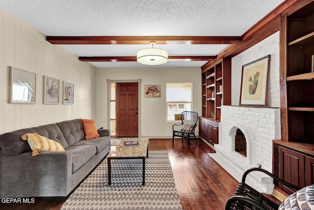 2723 Grant Ave, El Paso, TX 79930 - living room featuring a textured ceiling, dark wood-type flooring, a brick fireplace, beam ceiling, and wooden walls
