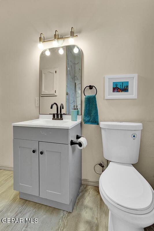 2723 Grant Ave, El Paso, TX 79930 - bathroom featuring toilet, baseboards, and vanity
