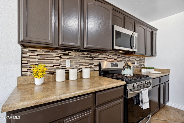 2709 Granite Rock Pl, El Paso, TX 79938 - kitchen with light tile patterned flooring, dark brown cabinetry, stainless steel appliances, baseboards, and decorative backsplash