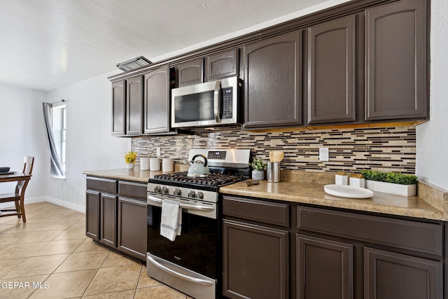 2709 Granite Rock Pl, El Paso, TX 79938 - kitchen featuring decorative backsplash, dark brown cabinetry, light tile patterned floors, baseboards, and stainless steel appliances