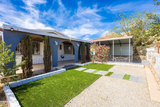 bungalow featuring covered porch, a front yard, fence, a patio, and stucco siding