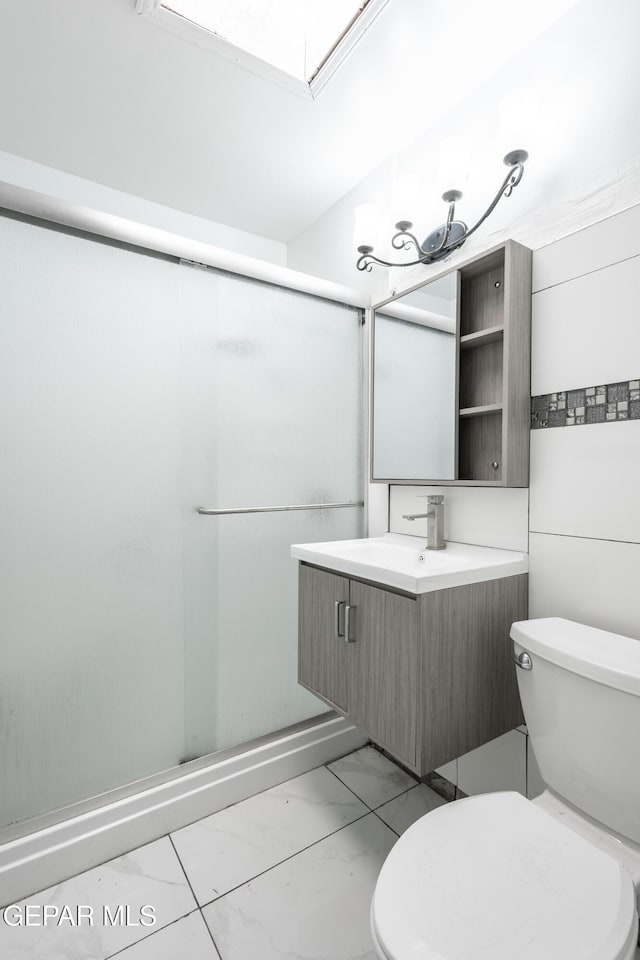 full bathroom with vanity, a stall shower, toilet, and marble finish floor