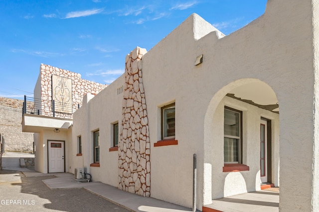 view of side of property with stucco siding and a balcony