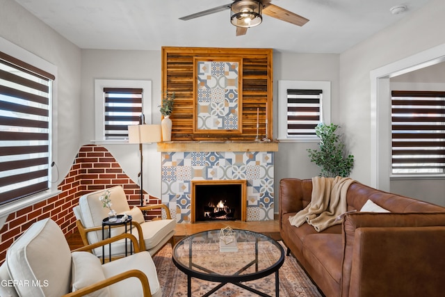living room with a ceiling fan and a fireplace