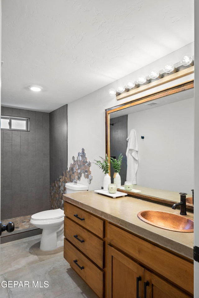 bathroom with vanity, toilet, and a stall shower