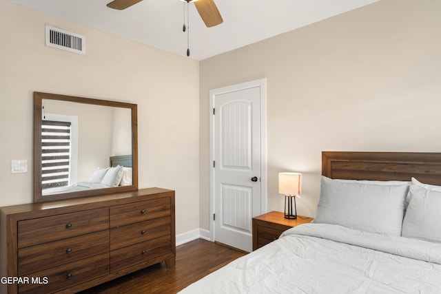 bedroom with baseboards, a ceiling fan, dark wood finished floors, and visible vents