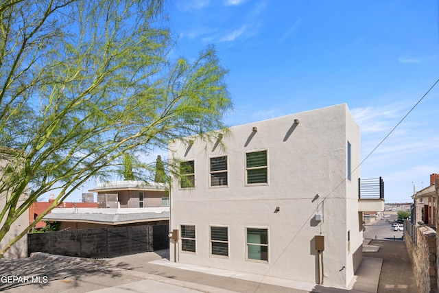 view of home's exterior with fence and stucco siding