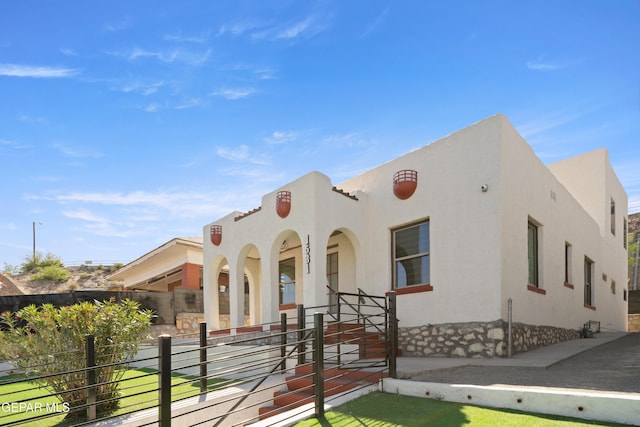 mediterranean / spanish house featuring fence private yard, stucco siding, and covered porch