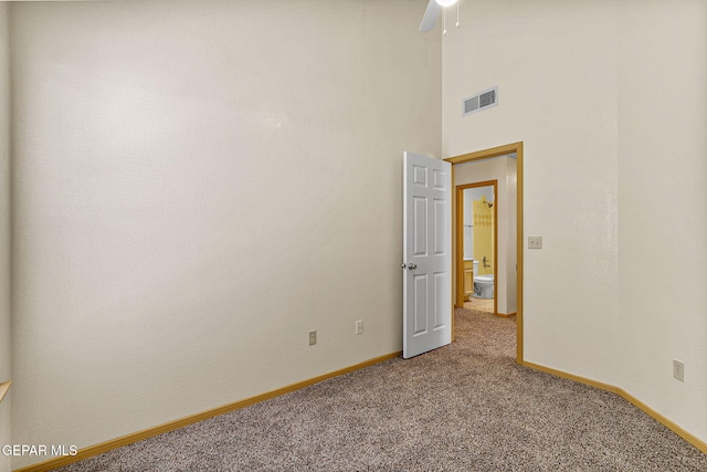 unfurnished room with visible vents, baseboards, a ceiling fan, and light carpet