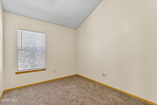 spare room with baseboards, carpet flooring, and a textured ceiling