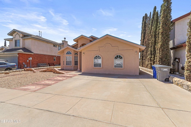 mediterranean / spanish house with concrete driveway and stucco siding