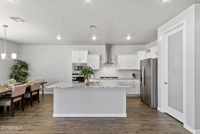 kitchen with visible vents, appliances with stainless steel finishes, white cabinetry, and wall chimney exhaust hood