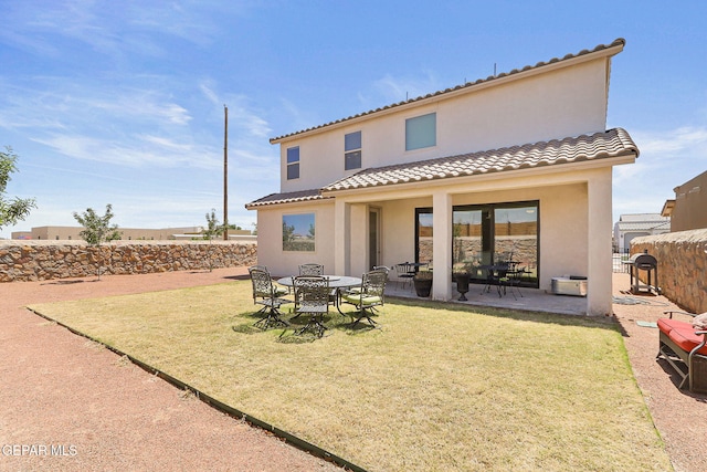 back of house featuring fence, a patio, stucco siding, a yard, and a tile roof