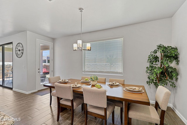 dining area featuring baseboards, a notable chandelier, wood finished floors, and a wealth of natural light