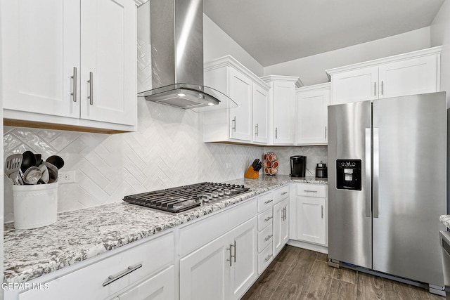 kitchen featuring appliances with stainless steel finishes, white cabinets, and wall chimney exhaust hood