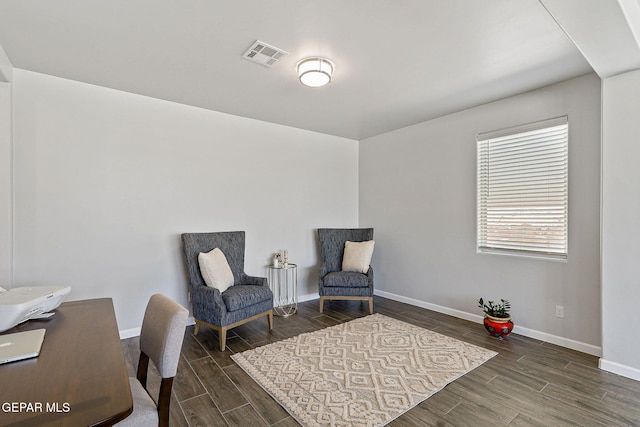 living area with wood finish floors, visible vents, and baseboards