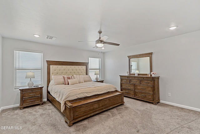 bedroom featuring visible vents, a ceiling fan, baseboards, and light carpet