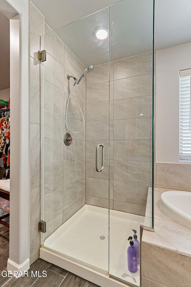 bathroom featuring wood finished floors and a stall shower