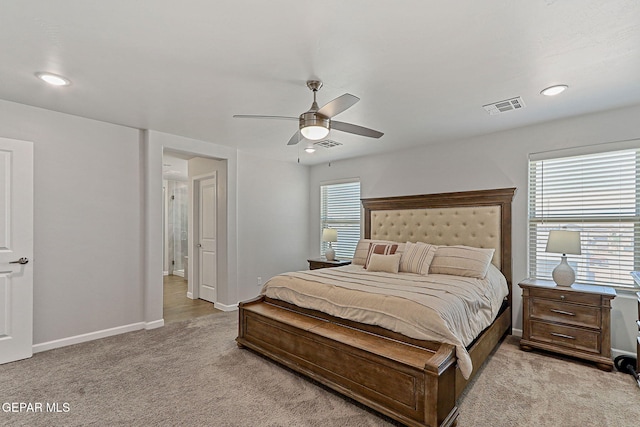 bedroom with visible vents, multiple windows, and light carpet