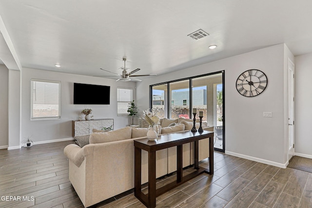 living area with baseboards, visible vents, ceiling fan, and wood tiled floor